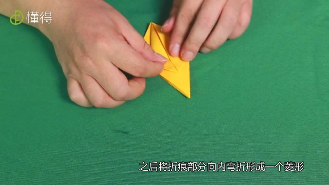 将折痕部分向内弯折形成一个菱形