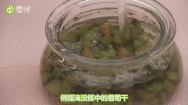 葡萄干怎么吃-倒醋淹没瓶中的葡萄干再用保鲜膜和布密封瓶口并浸泡一晚上